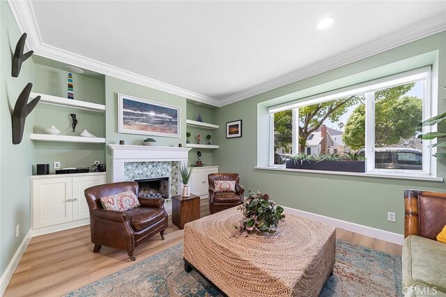 232 7th St, Seal Beach, CA 90740 - living area with wood finished floors, a high end fireplace, ornamental molding, built in shelves, and recessed lighting