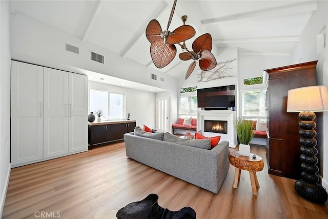 232 7th St, Seal Beach, CA 90740 - living area with a ceiling fan, light wood-style flooring, a warm lit fireplace, beamed ceiling, and high vaulted ceiling