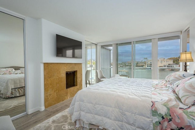 4073 Aladdin Dr, Huntington Beach, CA 92649 - bedroom with wood finished floors, a fireplace, a wall of windows, and access to exterior