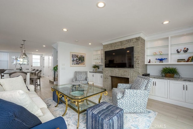 4073 Aladdin Dr, Huntington Beach, CA 92649 - living area with a large fireplace, recessed lighting, light wood-type flooring, and built in shelves
