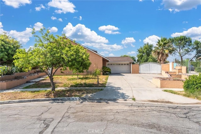 17571 Shamrock Ave, Fontana, CA 92336 - view of front facade featuring a gate, driveway, an attached garage, and stucco siding