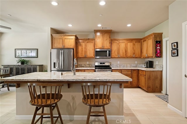 10 Harmony Park Cir, Chico, CA 95973 - kitchen with stainless steel appliances, recessed lighting, light countertops, a kitchen breakfast bar, and a kitchen island with sink