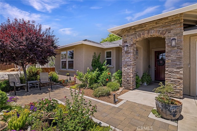 10 Harmony Park Cir, Chico, CA 95973 - doorway to property with stucco siding, stone siding, and a patio