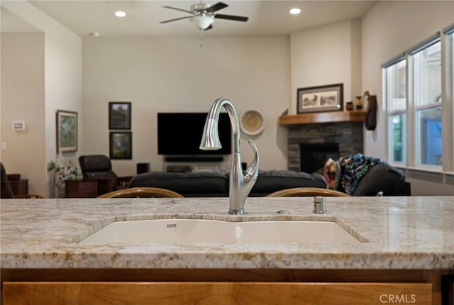 10 Harmony Park Cir, Chico, CA 95973 - kitchen with open floor plan, a ceiling fan, a fireplace, recessed lighting, and light stone countertops