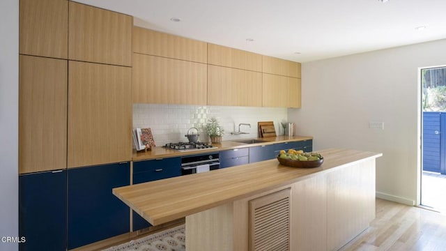 1070 Montecito Dr, Los Angeles, CA 90031 - kitchen featuring oven, tasteful backsplash, light wood-type flooring, modern cabinets, and butcher block countertops