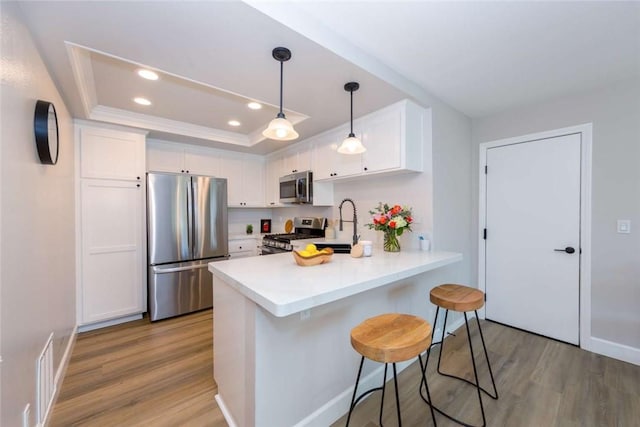 6313 Mockingbird St, Ventura, CA 93003 - kitchen featuring stainless steel appliances, light wood finished floors, recessed lighting, white cabinetry, and a peninsula