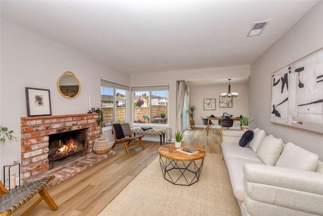 6313 Mockingbird St, Ventura, CA 93003 - living area featuring wood finished floors, a chandelier, and a brick fireplace