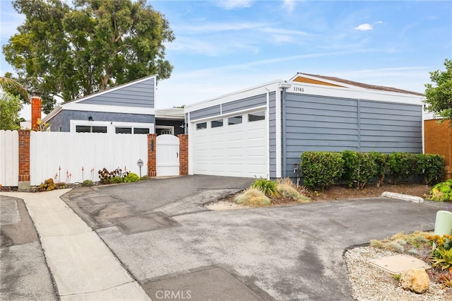 33586 Via Corvalian Unit 23, Dana Point, CA 92629 - garage featuring asphalt driveway and a gate