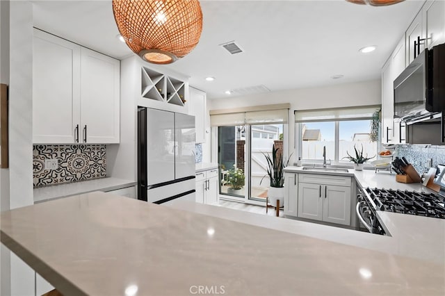 33586 Via Corvalian Unit 23, Dana Point, CA 92629 - kitchen with white fridge, gas range, black microwave, tasteful backsplash, and recessed lighting