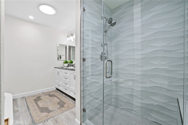 33586 Via Corvalian Unit 23, Dana Point, CA 92629 - bathroom with vanity, a shower stall, and wood finished floors