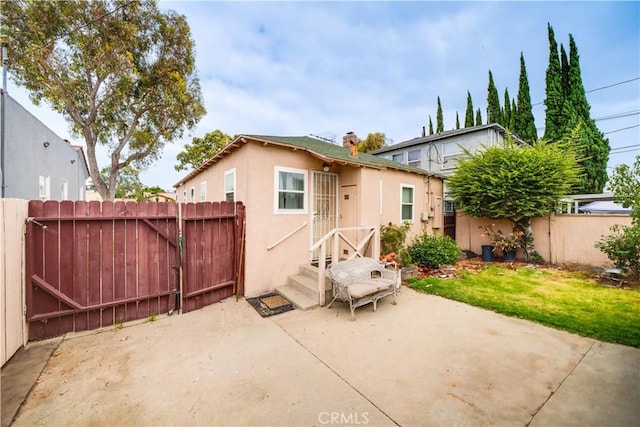 5870 Lemon Ave, Long Beach, CA 90805 - rear view of house featuring stucco siding, a patio, and a gate