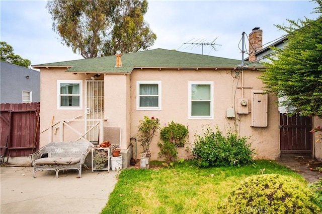 5870 Lemon Ave, Long Beach, CA 90805 - rear view of house featuring stucco siding, a patio, a chimney, and a shingled roof