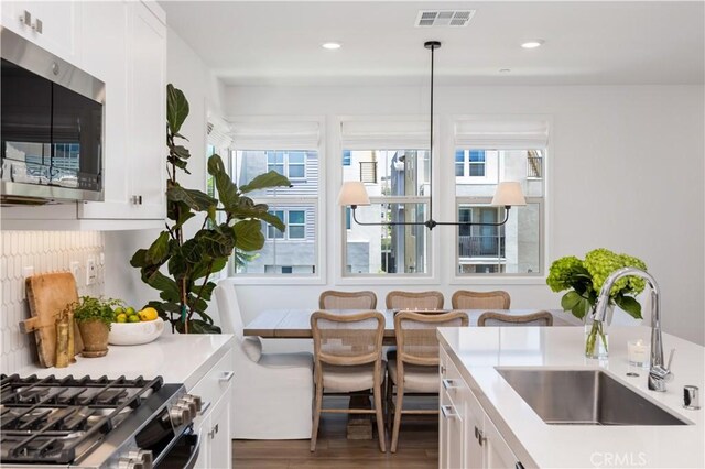 111 Juniper Dr, Rancho Mission Viejo, CA 92694 - kitchen featuring stainless steel microwave, wood finished floors, white cabinetry, light countertops, and recessed lighting