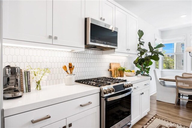 111 Juniper Dr, Rancho Mission Viejo, CA 92694 - kitchen featuring appliances with stainless steel finishes, light countertops, white cabinetry, and light wood-style floors