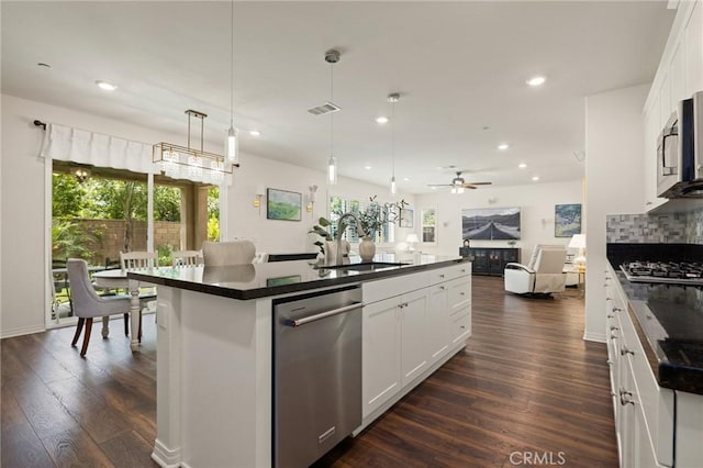 29273 Caravel Dr, Menifee, CA 92585 - kitchen featuring stainless steel appliances, dark countertops, open floor plan, healthy amount of natural light, and recessed lighting