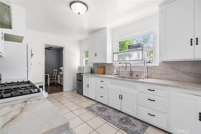 1335 W Burnett St, Long Beach, CA 90810 - kitchen featuring white appliances, backsplash, white cabinetry, light tile patterned floors, and light stone counters