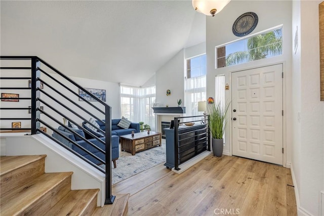 2578 Bryce Ct, Colton, CA 92324 - foyer entrance featuring high vaulted ceiling, stairway, light wood-style floors, and a fireplace