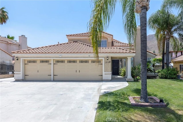 2578 Bryce Ct, Colton, CA 92324 - mediterranean / spanish-style house featuring concrete driveway, an attached garage, a front yard, and stucco siding