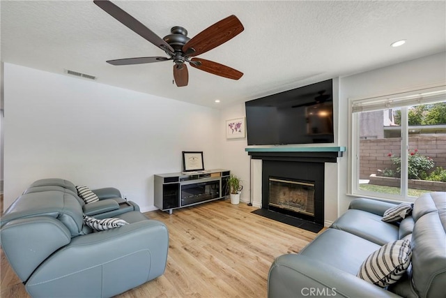 2578 Bryce Ct, Colton, CA 92324 - living room with a fireplace with flush hearth, wood finished floors, ceiling fan, recessed lighting, and a textured ceiling