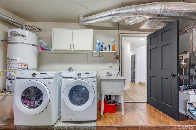 2578 Bryce Ct, Colton, CA 92324 - washroom with washing machine and dryer, cabinet space, light wood-style flooring, and water heater