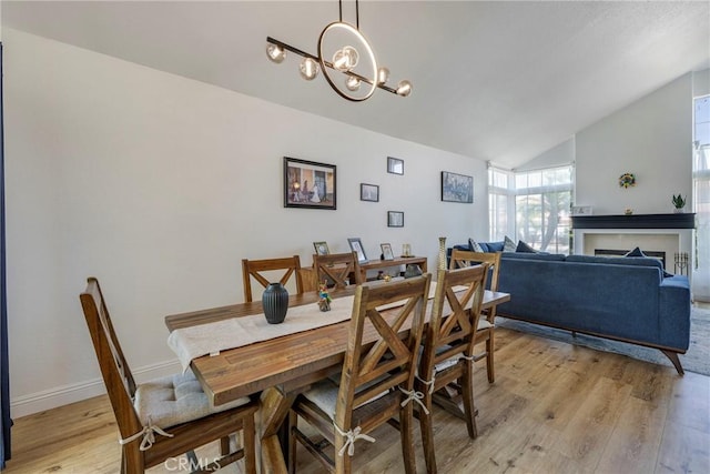 2578 Bryce Ct, Colton, CA 92324 - dining space featuring light wood-type flooring, vaulted ceiling, and a chandelier