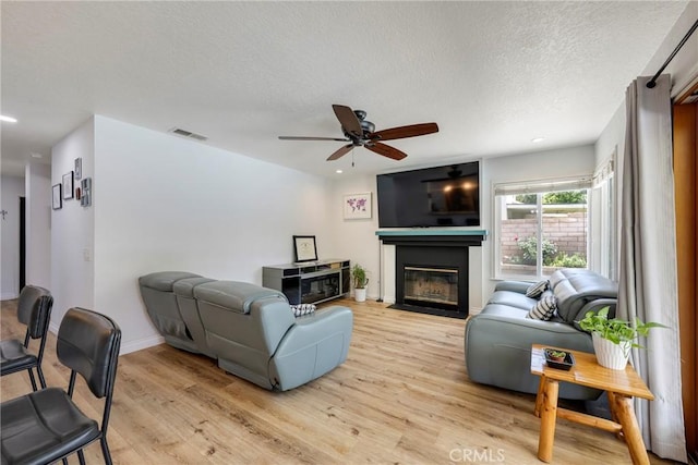 2578 Bryce Ct, Colton, CA 92324 - living area featuring a fireplace with flush hearth, light wood-style flooring, ceiling fan, a textured ceiling, and recessed lighting