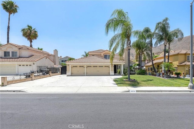 2578 Bryce Ct, Colton, CA 92324 - mediterranean / spanish-style home featuring driveway, a garage, a front yard, a tile roof, and stucco siding