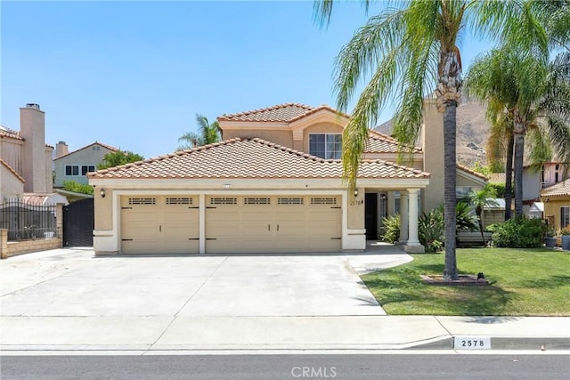 2578 Bryce Ct, Colton, CA 92324 - mediterranean / spanish-style home with a garage, stucco siding, concrete driveway, a tile roof, and a front lawn