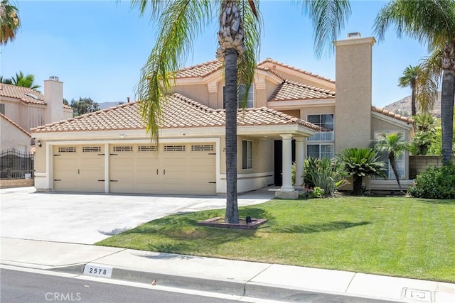 2578 Bryce Ct, Colton, CA 92324 - mediterranean / spanish home with an attached garage, stucco siding, concrete driveway, a front yard, and a tile roof