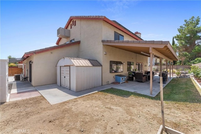 44125 Dusty Rd, Lancaster, CA 93536 - rear view of house featuring a patio area, a fenced backyard, a storage unit, and stucco siding