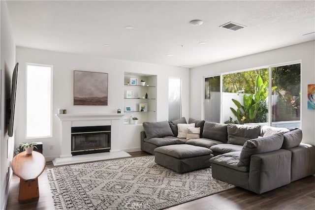 705 El Berro, San Clemente, CA 92672 - living area featuring wood finished floors, built in shelves, a glass covered fireplace, and recessed lighting
