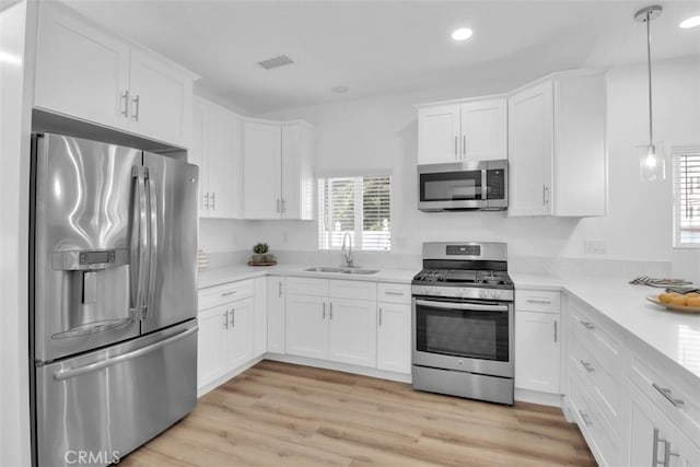 2697 Merced St, Los Angeles, CA 90065 - kitchen with appliances with stainless steel finishes, light countertops, white cabinets, recessed lighting, and light wood-style floors