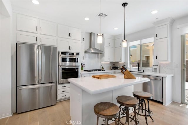 783 Longhorn, Rancho Mission Viejo, CA 92694 - kitchen with stainless steel appliances, wall chimney exhaust hood, white cabinetry, light wood-style floors, and light countertops