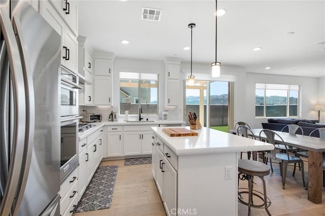 783 Longhorn, Rancho Mission Viejo, CA 92694 - kitchen featuring stainless steel appliances, open floor plan, a breakfast bar, a center island, and light wood finished floors