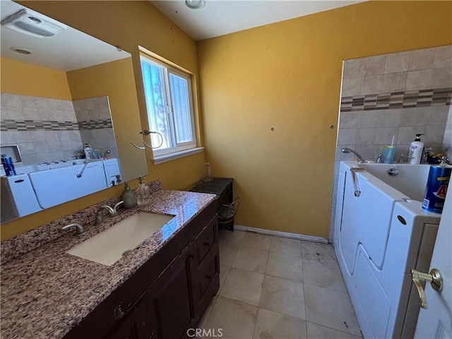 10164 Hampshire St, Rancho Cucamonga, CA 91730 - bathroom featuring a garden tub, vanity, washer / dryer, and tile patterned floors