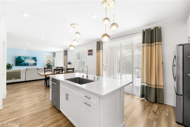 16526 Trailblazer Ave, Chino, CA 91708 - kitchen featuring stainless steel appliances, light countertops, white cabinetry, a kitchen island with sink, and light wood-type flooring