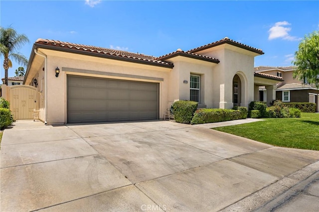 11529 Trailrun Ct, Riverside, CA 92505 - mediterranean / spanish-style home featuring concrete driveway, stucco siding, an attached garage, a gate, and a front lawn