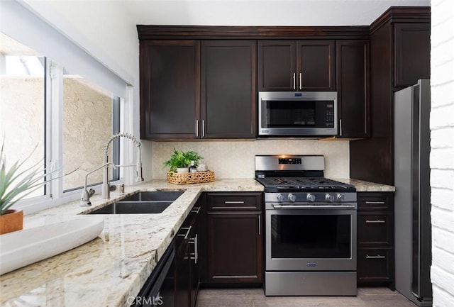 81 Golden Glen St Unit 1, Irvine, CA 92604 - kitchen featuring appliances with stainless steel finishes, healthy amount of natural light, dark brown cabinetry, and light stone counters