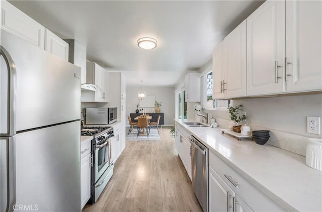 21237 Silver Cloud Dr, Diamond Bar, CA 91765 - kitchen with stainless steel appliances, white cabinets, light countertops, light wood-type flooring, and wall chimney range hood