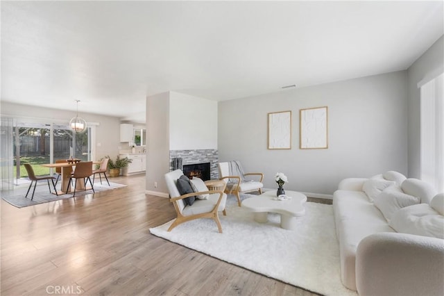 21237 Silver Cloud Dr, Diamond Bar, CA 91765 - living room featuring plenty of natural light, light wood-style floors, and a stone fireplace