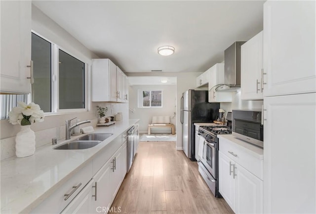 21237 Silver Cloud Dr, Diamond Bar, CA 91765 - kitchen featuring stainless steel appliances, wall chimney range hood, light wood-style floors, light countertops, and white cabinets