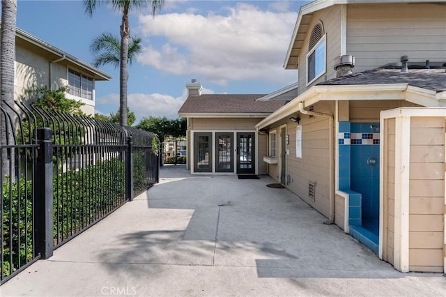 3555 Grove St Unit 231, Lemon Grove, CA 91945 - view of side of property with a gate, a chimney, and a shingled roof
