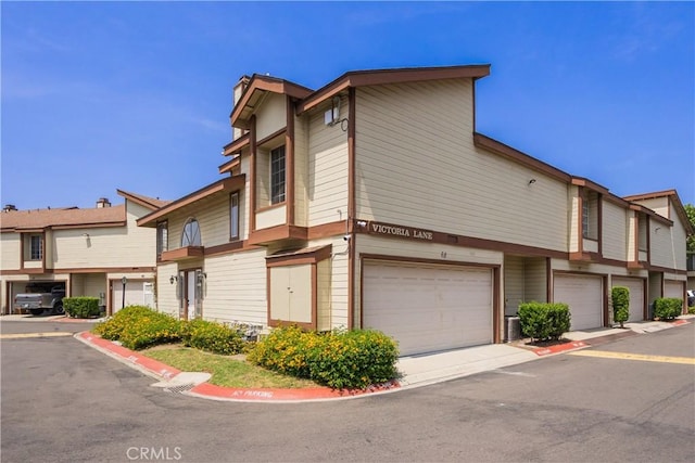 8939 Gallatin Rd Unit 68, Pico Rivera, CA 90660 - view of front of house featuring an attached garage and a chimney