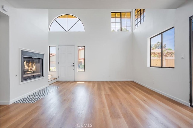 8939 Gallatin Rd Unit 68, Pico Rivera, CA 90660 - entrance foyer featuring light wood-style floors, a towering ceiling, and a lit fireplace