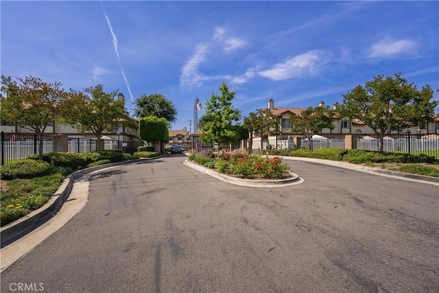 8939 Gallatin Rd Unit 68, Pico Rivera, CA 90660 - view of asphalt street featuring a residential view, curbs, a gated entry, and street lights