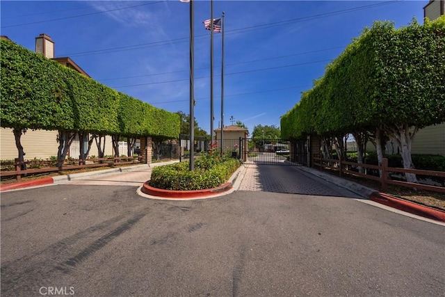8939 Gallatin Rd Unit 68, Pico Rivera, CA 90660 - view of asphalt street featuring a gate, curbs, and a gated entry
