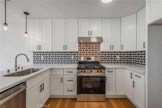 8939 Gallatin Rd Unit 68, Pico Rivera, CA 90660 - kitchen with appliances with stainless steel finishes, under cabinet range hood, white cabinetry, decorative light fixtures, and backsplash