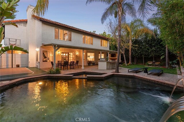 6137 Rustling Oaks Dr, Agoura Hills, CA 91301 - back of property featuring a patio area, stucco siding, a bar, a pool with connected hot tub, and a chimney