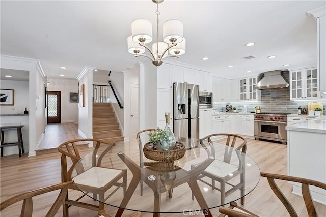 6137 Rustling Oaks Dr, Agoura Hills, CA 91301 - dining space featuring light wood finished floors, recessed lighting, stairs, ornamental molding, and a chandelier