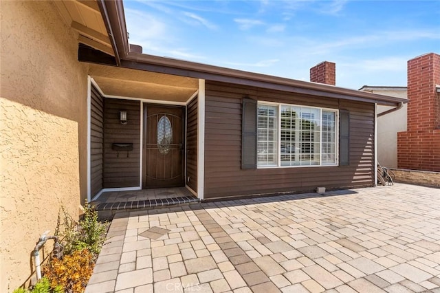8950 Brentford Ave, San Diego, CA 92126 - view of exterior entry featuring a patio, a chimney, and stucco siding